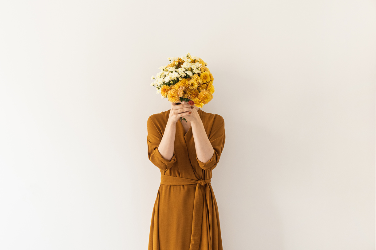 Woman Covering Face with Bouquet of Flowers